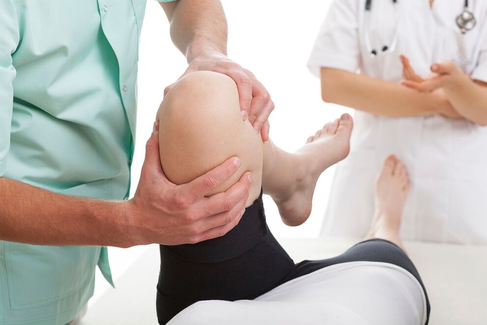 doctor examining knee for joint pain