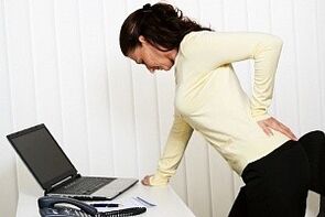 a woman has back pain in the lumbar region